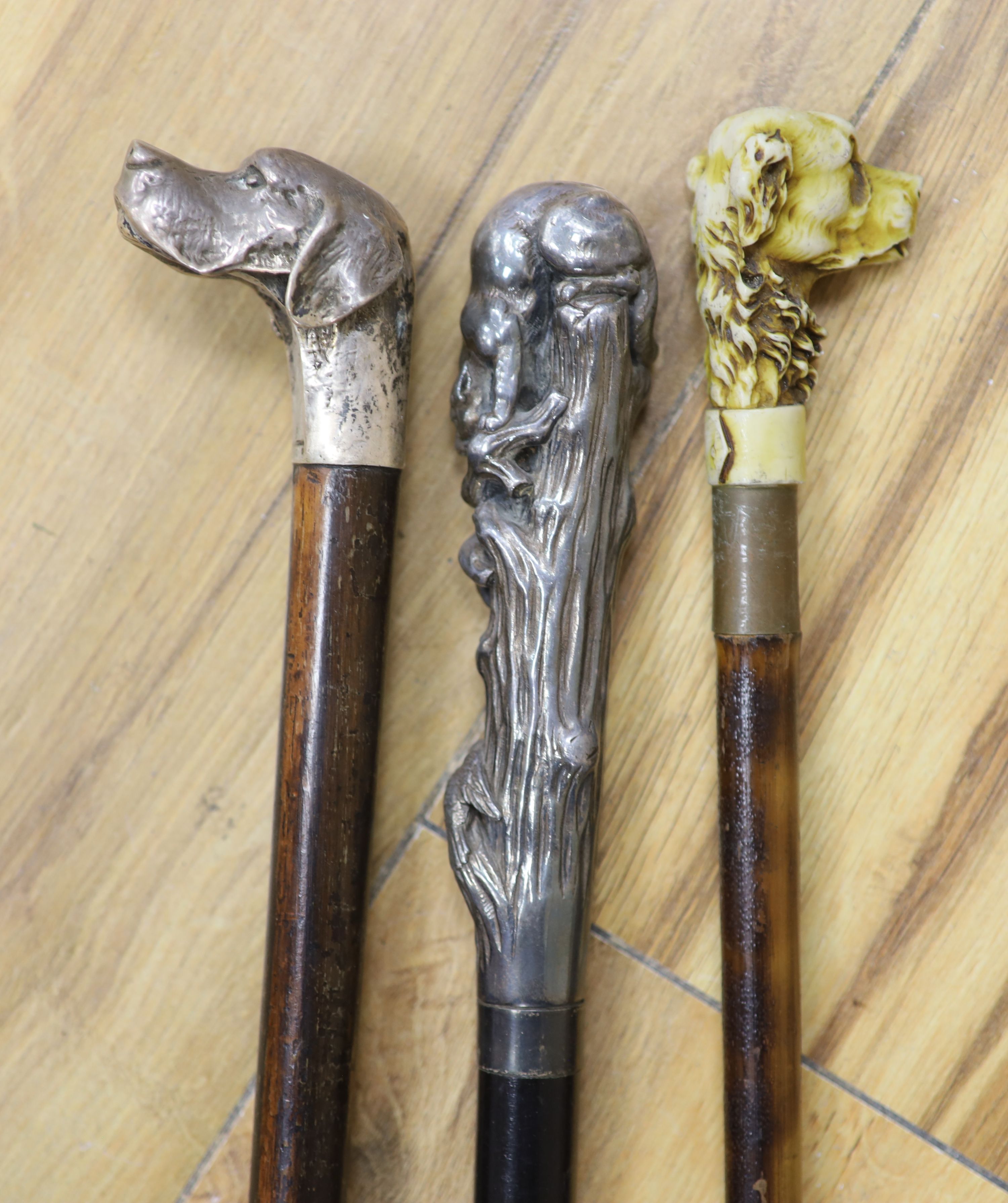 A big cat sterling-mounted cane, a dogs head 925 sterling mounted cane and a resin dogs head mounted cane